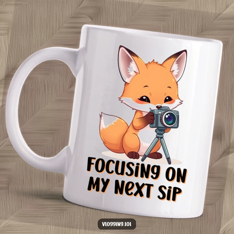 Funny mug showing a curious fox playfully interacting with a miniature camera on a tripod, looking intently at the lens.